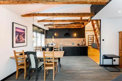 a kitchen and dining room with a wooden table and chairs at Old Town Wooden Loft Apartment by BookingHost in Kraków