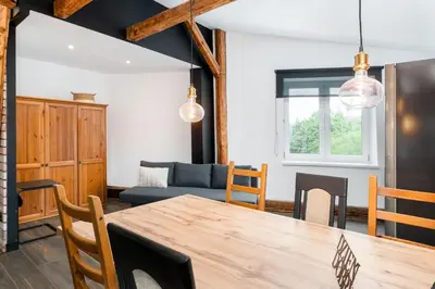 a dining room with a table and a couch at Old Town Wooden Loft Apartment by BookingHost in Kraków