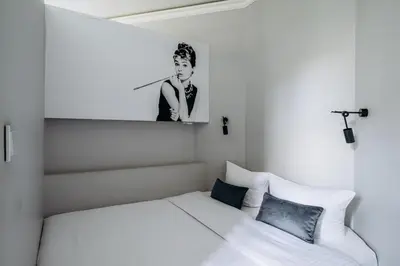 a bedroom with a bed and a picture of a man at Apartament Marylin in Kraków