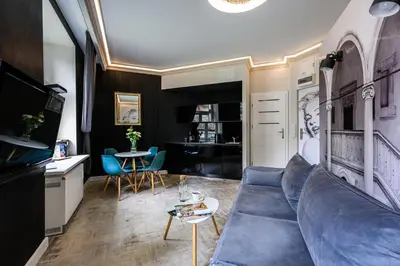 a living room with a blue couch and a table at Apartament Marylin in Kraków