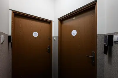 two brown doors with white signs on them in a bathroom at Apartament Marylin in Kraków