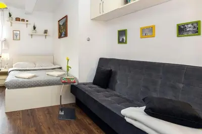 a living room with a couch and a bed at Cosy Studio in Kraków