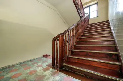 a wooden staircase in a building with a window at Cosy Studio in Kraków