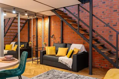a living room with a couch and a brick wall at 500 Year House - Kraków Old Town - Historic Apartments by Staymoovers in Kraków