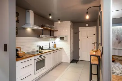 a kitchen with white cabinets and a sink at 500 Year House - Kraków Old Town - Historic Apartments by Staymoovers in Kraków