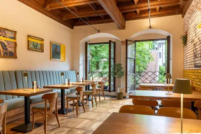 a restaurant with tables and chairs and windows at 500 Year House - Kraków Old Town - Historic Apartments by Staymoovers in Kraków