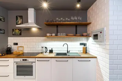 a kitchen with white cabinets and a sink at 500 Year House - Kraków Old Town - Historic Apartments by Staymoovers in Kraków