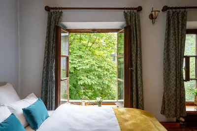 a bedroom with a bed and a large window at 500 Year House - Kraków Old Town - Historic Apartments by Staymoovers in Kraków