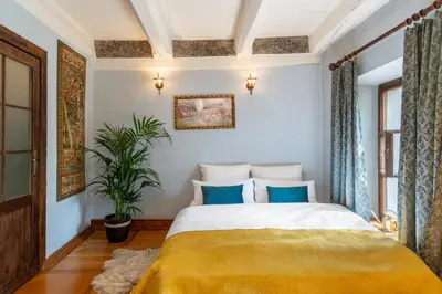 a bedroom with a large bed with blue pillows at 500 Year House - Kraków Old Town - Historic Apartments by Staymoovers in Kraków