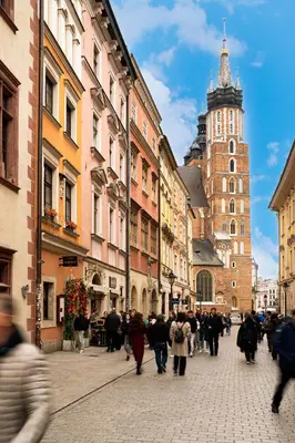 a group of people walking down a city street at 500 Year House - Kraków Old Town - Historic Apartments by Staymoovers in Kraków