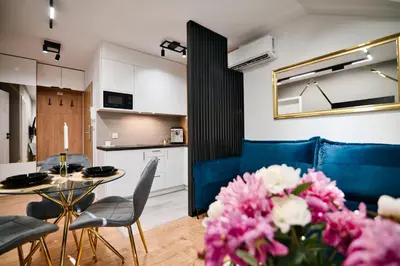 a living room with a table and some pink flowers at Vista Jaśmin 22 by Housine in Zator