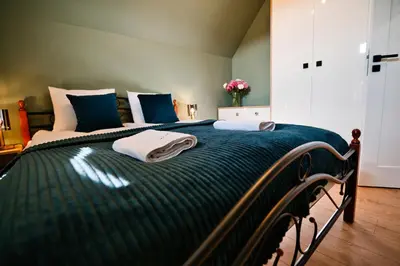 a green bed with two towels on top of it at Vista Jaśmin 22 by Housine in Zator