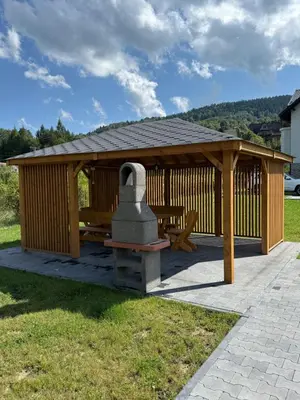 a wooden gazebo with a bench and a monument at BABIA GÓRA Dream Apart in Zawoja