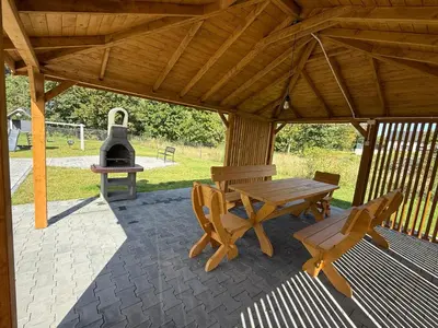 a wooden pavilion with a picnic table and a grill at BABIA GÓRA Dream Apart in Zawoja