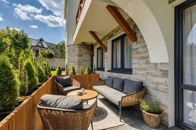 a patio with wicker chairs and a table at BABIA GÓRA Dream Apart in Zawoja
