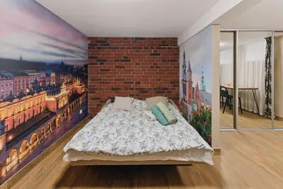 a bedroom with a brick wall and a bed with pillows at Old Town Gateway in Kraków