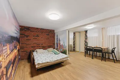 a bedroom with a bed and a brick wall at Old Town Gateway in Kraków