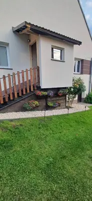 a house with a wooden fence and a yard at Pod Górą in Wiśniowa