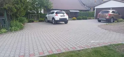 two cars are parked in a driveway at Pod Górą in Wiśniowa