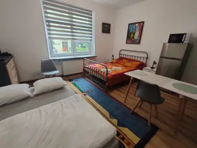 a bedroom with two beds and a desk and a table at Apartment with kitchenette in Kraków