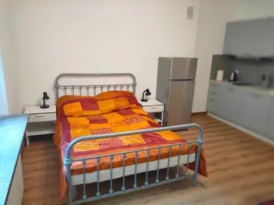 a bedroom with a bed with an orange blanket at Apartment with kitchenette in Kraków