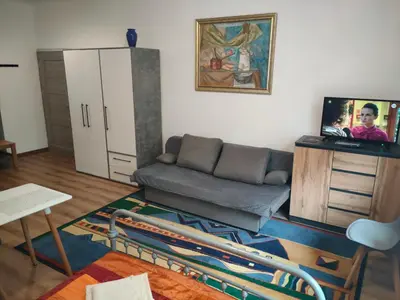 a living room with a couch and a refrigerator at Apartment with kitchenette in Kraków