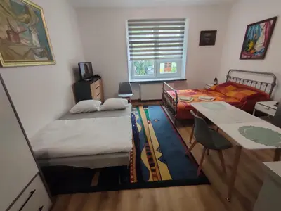 a room with two beds and a table and a bed at Apartment with kitchenette in Kraków