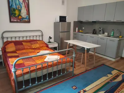 a bedroom with a bed and a table and a kitchen at Apartment with kitchenette in Kraków