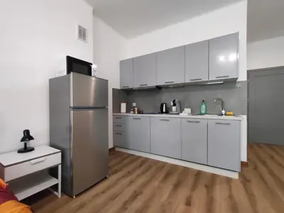 a kitchen with white cabinets and a stainless steel refrigerator at Apartment with kitchenette in Kraków