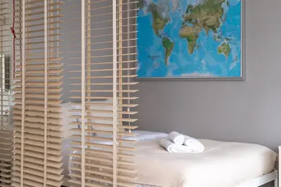 a room with a window with blinds on a bed at Lindego Park Comfy Studio by BookingHost in Kraków