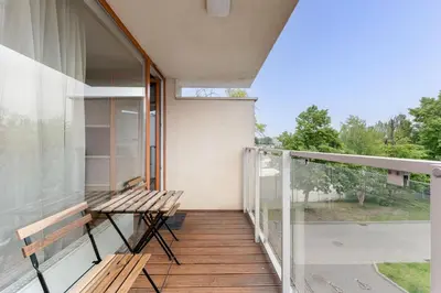a balcony of a house with a wooden bench at Lindego Park Comfy Studio by BookingHost in Kraków