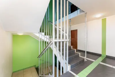 a staircase in a hallway with green and white walls at Lindego Park Comfy Studio by BookingHost in Kraków
