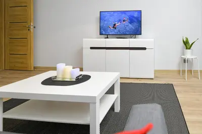 a living room with a white table and a tv at JJ Apartment Zator Energylandia in Zator