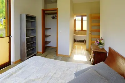 a bedroom with a bed and a bathroom with a tub at Babie Zacisze in Zawoja