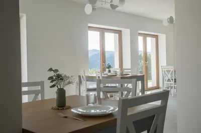 a dining room with a table and chairs at Nad Jeziorem in Rożnów