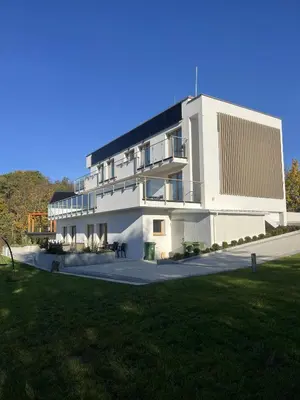 a large white building with a lawn in front of it at Nad Jeziorem in Rożnów