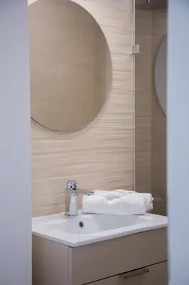 a bathroom with a white sink and a mirror at Nad Jeziorem in Rożnów