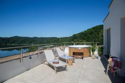 a patio with chairs and a tub on a balcony at Nad Jeziorem in Rożnów