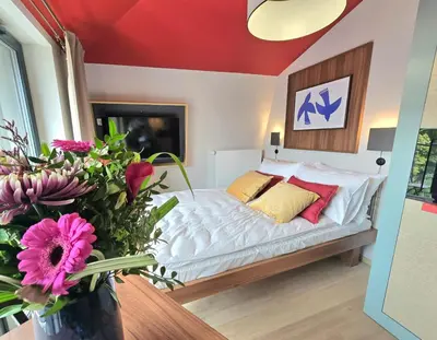 a bedroom with a bed and a vase of flowers at Royal Kątowa Apartment in Kraków