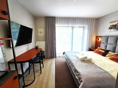 a hotel room with a bed and a desk at Royal Kątowa Apartment in Kraków