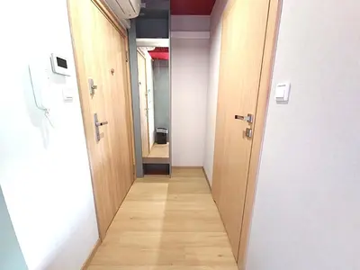 a corridor of an empty hallway with wooden doors at Royal Kątowa Apartment in Kraków