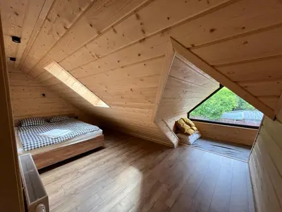an attic room with a bed and a window at Ostoja Zawoja in Zawoja