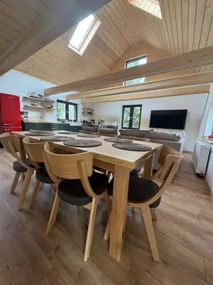 a dining room with a wooden table and chairs at Ostoja Zawoja in Zawoja