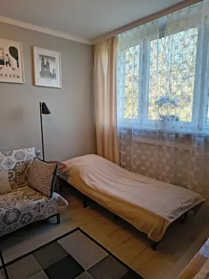 a bed in a room with a window at Apartament Kraków Łobzów in Kraków