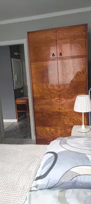 a bedroom with a large wooden closet and a bed at Apartament Kraków Łobzów in Kraków