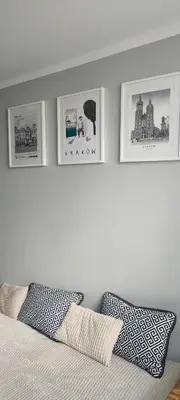 a bedroom with four pictures on the wall above a bed at Apartament Kraków Łobzów in Kraków
