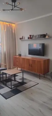 a living room with a flat screen tv and a coffee table at Apartament Kraków Łobzów in Kraków