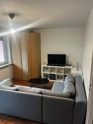 a living room with a couch and a flat screen tv at Cozy studio with Balcony & Parking in Kraków