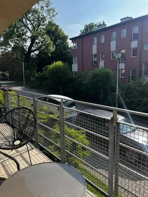 a balcony with a table and chairs and a building at Cozy studio with Balcony & Parking in Kraków