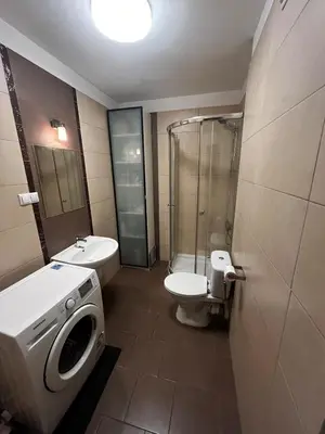 a bathroom with a shower toilet and a washing machine at Cozy studio with Balcony & Parking in Kraków
